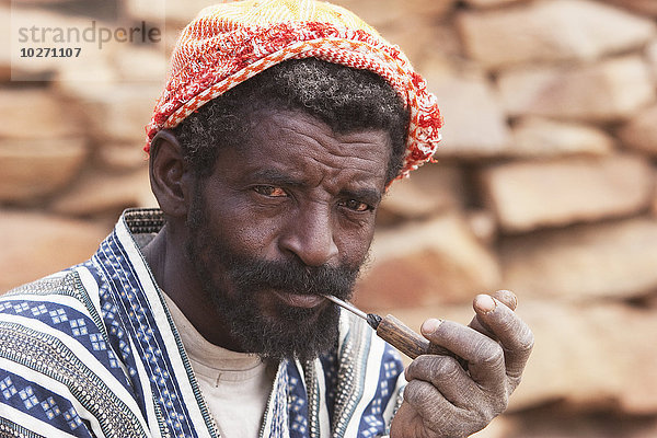 Porträt eines Dogon-Mannes beim Pfeiferauchen in Tireli  Mali