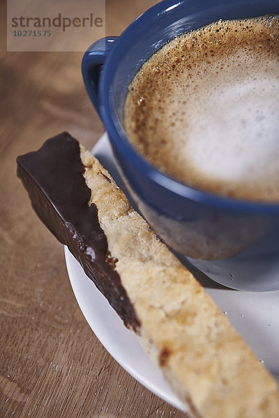 Cappuccino und in Schokolade getauchte Biscotti auf einem weißen Teller; Ontario  Kanada'.