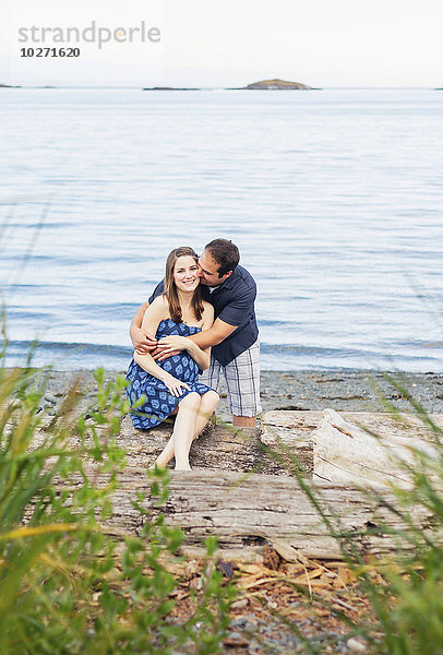 Ein junges Paar  das sein erstes Kind erwartet  posiert für Schwangerschaftsporträts an einem Strand am Meer; Nanaimo  British Columbia  Kanada