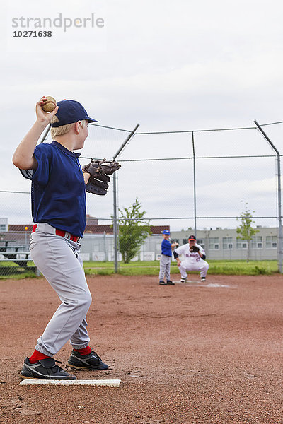 Ein kleiner Junge in seiner Baseball-Uniform bereitet sich darauf vor  seinem Bruder einen Wurf zuzuwerfen; Fort McMurray  Alberta  Kanada
