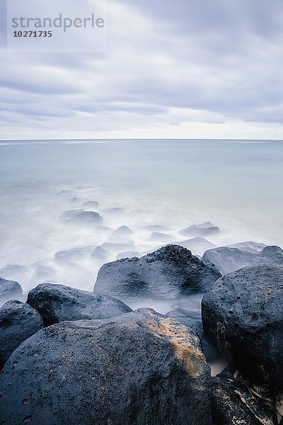 Brandung umspült Felsen und Treibholz; Wailua  Kauai  Hawaii  Vereinigte Staaten von Amerika'.