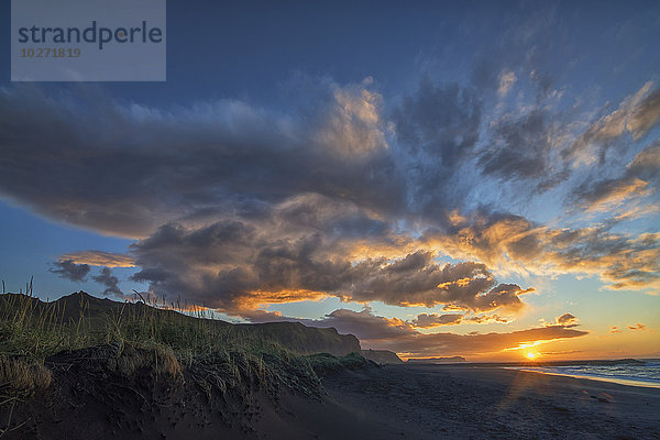 Ein wunderschöner Sonnenaufgang über dem Strand und der Stadt Vik an der Südküste von Island; Vik  Island