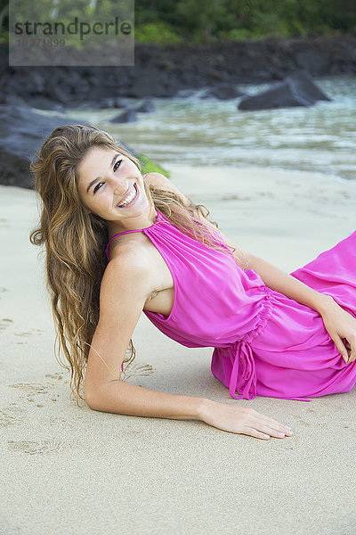 Porträt einer Frau in einem rosa Kleid am Strand; Kauai  Hawaii  Vereinigte Staaten von Amerika'.