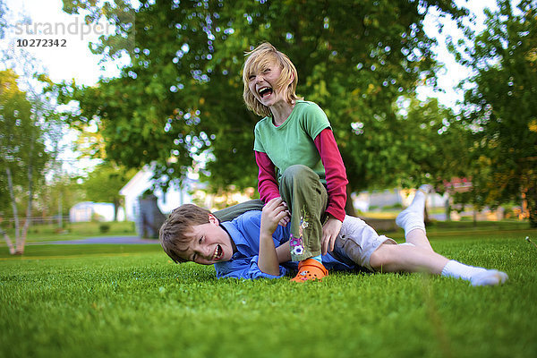 Ein Junge und ein Mädchen ringen im Gras; Picton  Ontario  Kanada'.
