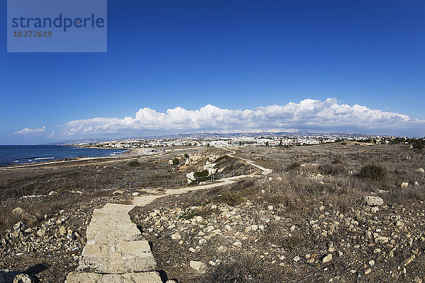 Ein zerklüfteter Steinweg durch eine trockene Landschaft am Ufer des Wassers; Paphos  Zypern
