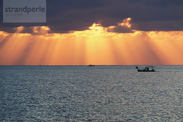 Dramatischer Himmel mit Sonnenstrahlen  die aus den Gewitterwolken über dem Horizont herausfiltern; Paphos  Zypern'.