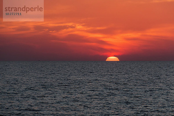 Dramatischer roter Himmel mit Sonnenuntergang unter dem Meer und dem Horizont; Paphos  Zypern'.
