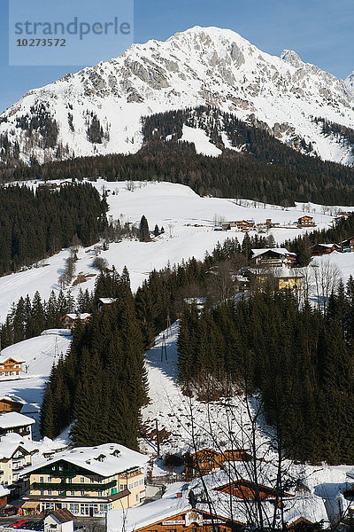 Berge  Skipisten  schneebedeckte Holzhäuser und Tannenbäume im alpinen Skigebiet Filzmoos  Österreich'.
