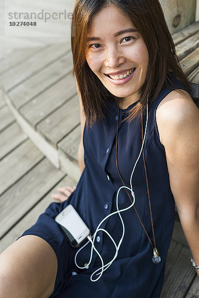 Chinesisches Mädchen lächelt und hört Musik; Xiamen  Provinz Fujian  China