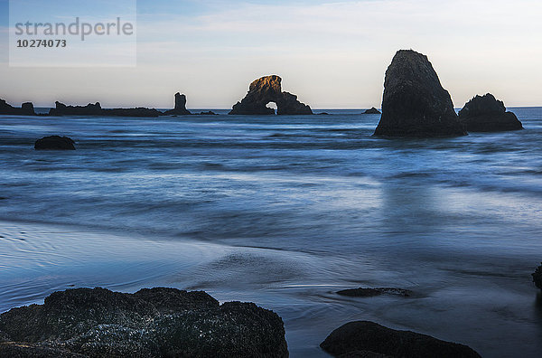 Die Sonne geht über den Felsen auf; Cannon Beach  Oregon  Vereinigte Staaten von Amerika'.