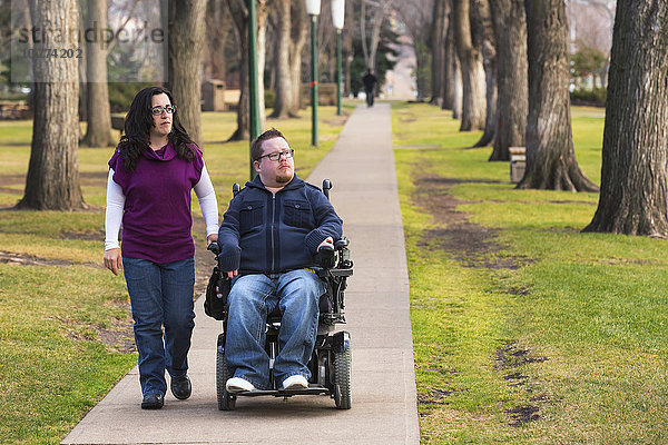 Behinderter Ehemann geht mit seiner Frau im Herbst in einem Park spazieren; Edmonton  Alberta  Kanada'.