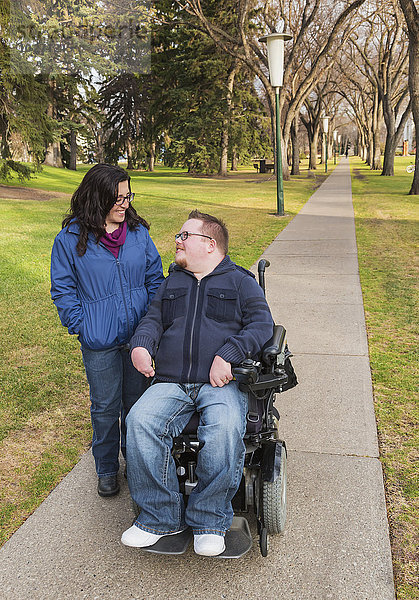 Behinderter Mann im Gespräch mit seiner Frau bei einem Herbstspaziergang in einem Park; Edmonton  Alberta  Kanada'.