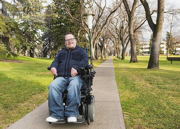 Behinderter Mann in seinem Elektrorollstuhl in einem Park im Herbst; Edmonton  Alberta  Kanada'.