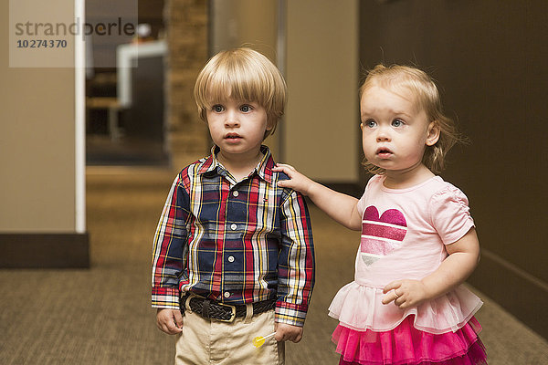 Zwei Kleinkinder  die den Gang in einer zahnärztlichen Familienpraxis entlanggehen; Edmonton  Alberta  Kanada'.