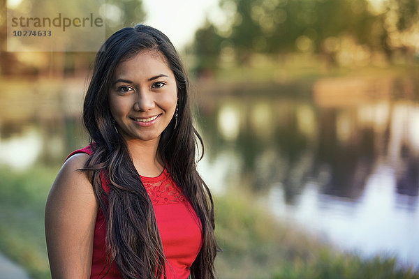 Porträt einer jungen philippinischen Frau in einem Stadtpark im Herbst; St. Albert  Alberta  Kanada'.