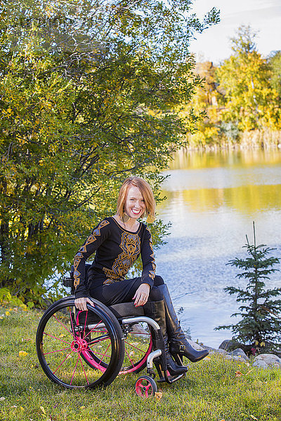 Porträt einer jungen behinderten Frau im Rollstuhl in einem Stadtpark im Herbst; Edmonton  Alberta  Kanada'.