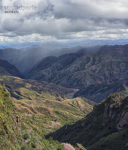 Die farbenfrohe Berglandschaft des Toro-Toro-Nationalparks mit einem Regenschauer in der Ferne; Bolivien'.