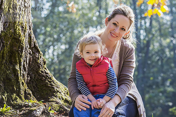 Eine Mutter hält ihren kleinen Sohn in einem Park im Herbst; Langley  British Columbia  Kanada'.