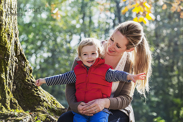 Eine Mutter hält ihren kleinen Sohn in einem Park im Herbst; Langley  British Columbia  Kanada'.