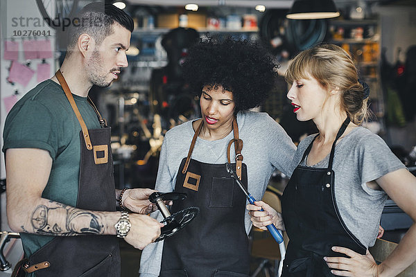 Multiethnische Mechaniker halten Werkzeuge in der Werkstatt