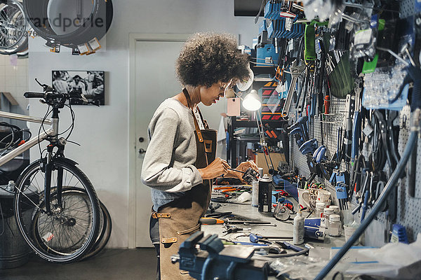 Seitenansicht der Mechanikerin in der Fahrradwerkstatt