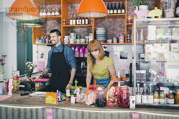 Mann und Frau bei der Arbeit am Cafe Counter