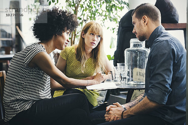 Mittlere erwachsene Arbeiter diskutieren im Einrichtungsgeschäft