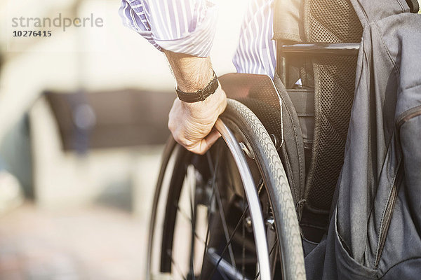 Abgeschnittenes Bild des Menschen im Rollstuhl im Freien