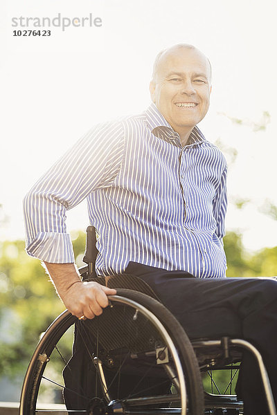 Porträt eines glücklichen Mannes im Rollstuhl im Freien