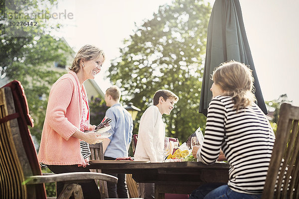 Glückliche Familie beim Essen im Hof