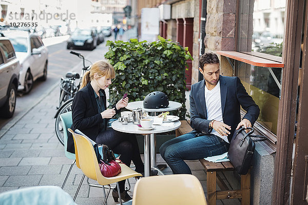 Berufspendler sitzen im Straßencafé