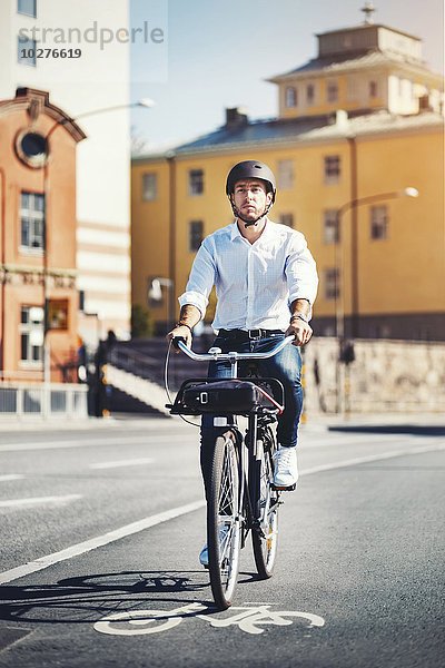 Geschäftsmann pendelt mit dem Fahrrad in der Stadt