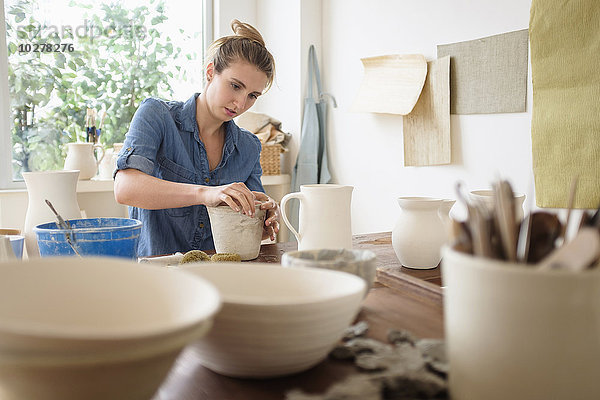 Junge Frau beim Töpfern im Atelier