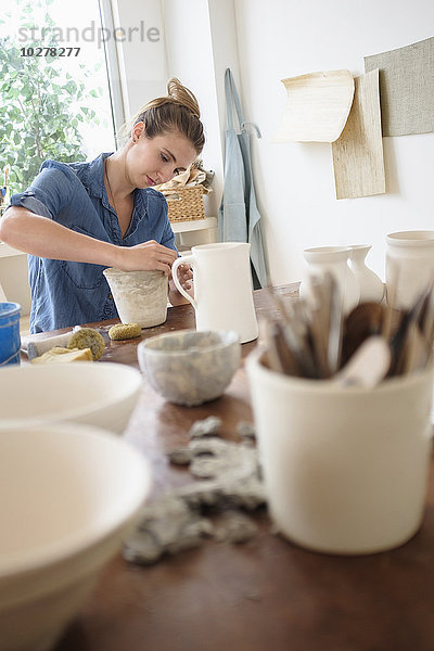 Junge Frau beim Töpfern im Atelier