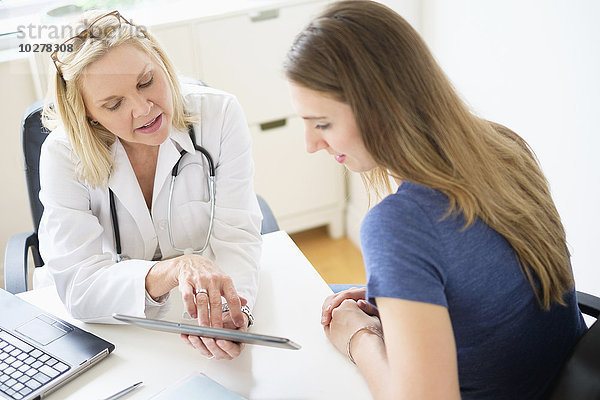 Arzt im Gespräch mit Patient im Büro