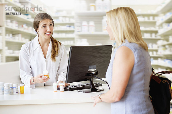 Patient im Gespräch mit dem Apotheker in der Apotheke