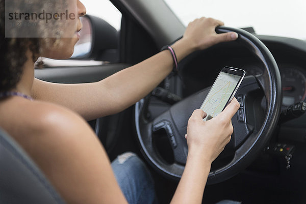Junge Frau  die beim Autofahren eine SMS schreibt