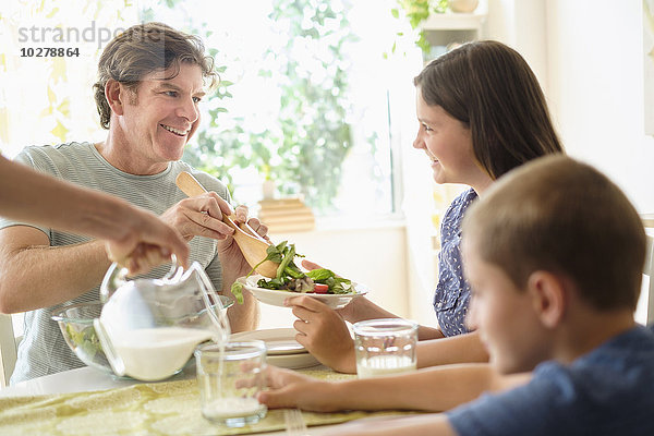 Kinder (8-9  10-11) essen Salat mit ihren Eltern