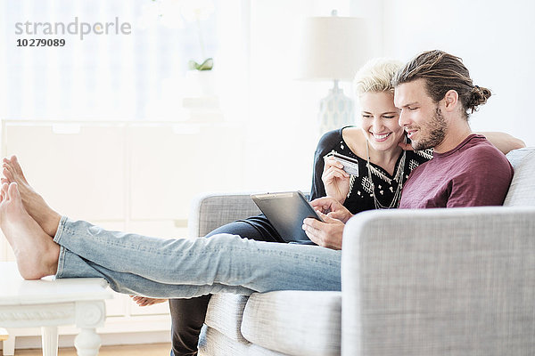 Ehepaar benutzt Tablet-PC auf Sofa
