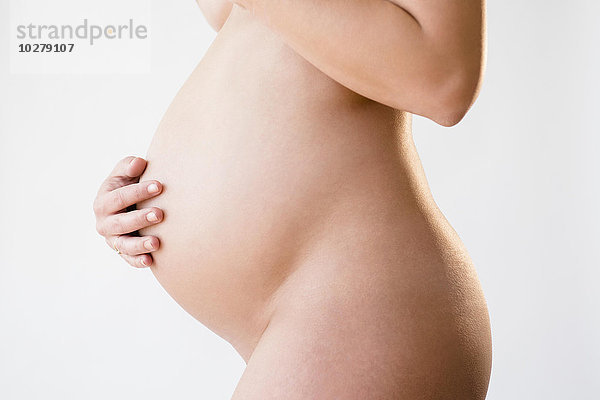 Studioaufnahme einer nackten  schwangeren Frau