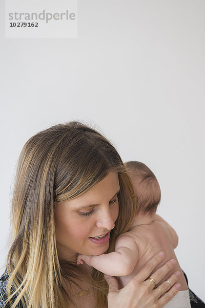 Mutter hält kleines Mädchen (2-5 Monate) im Arm