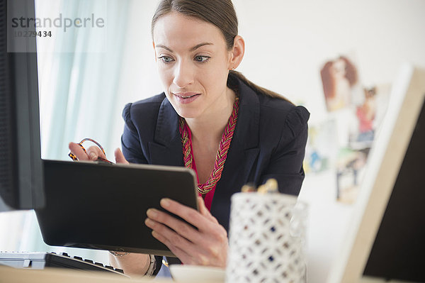 Frau benutzt Tablet im Büro