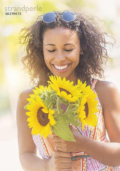 Porträt einer lächelnden Frau mit Sonnenblumen