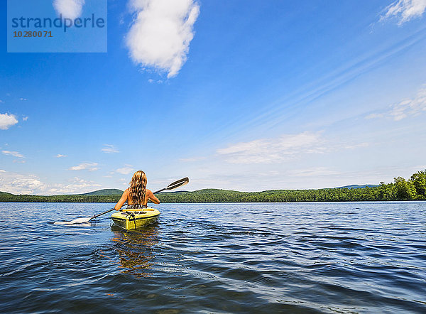 Junge Frau beim Kajakfahren auf einem See