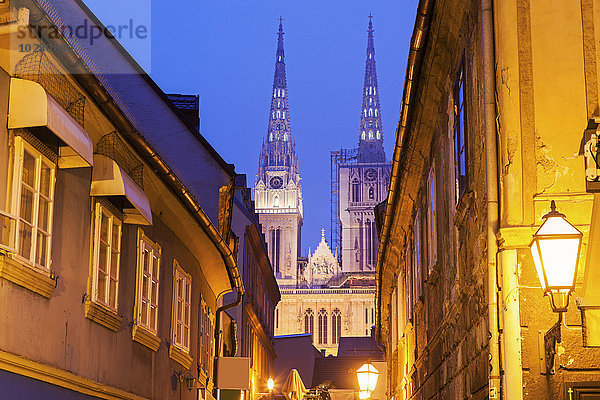 Beleuchtete Straße und Türme der Kathedrale von Zagreb