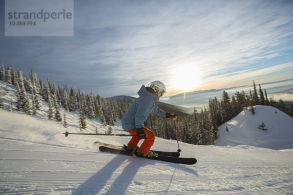 Älterer Mann auf Skipiste bei Sonnenuntergang