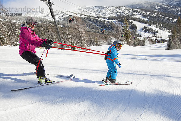 Mutter bringt Sohn (4-5) das Skifahren bei