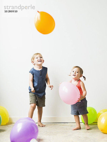 Kinder (2-3) spielen mit Luftballons