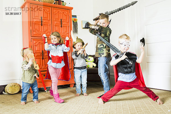 Kinder (2-3  4-5  6-7) in Superheldenkostümen beim Spielen zu Hause