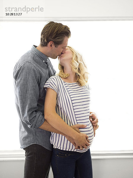 Ehemann küsst schwangere Frau